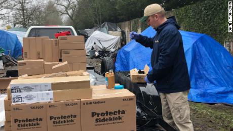 A pest control technician baits a trap with peanut butter.