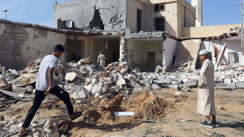 Residents check the site of an air strike on the outskirts of Tripoli in October, 2019. 