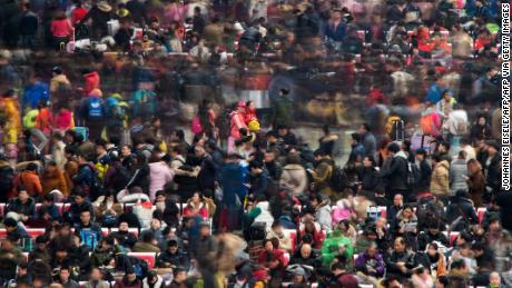 Passengers wait to board their trains as they head to their hometown for the Lunar New Year holiday at a railway station in Shanghai on January 30, 2016. 