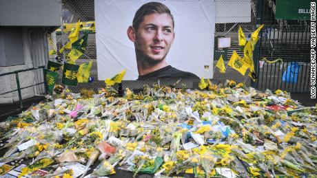 Yellow flowers are displayed in front of the portrait of Argentinian forward Emiliano Sala