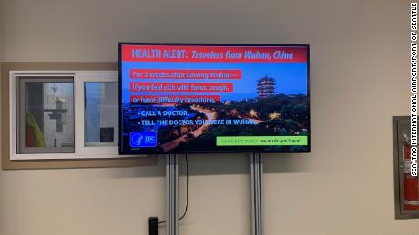 A sign at the international arrivals area of Seattle-Tacoma International Airport instructs travelers coming from Wuhan, China, to watch for symptoms of coronavirus. 