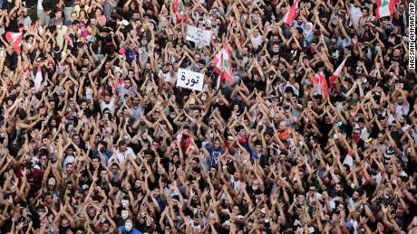 Anti-government protesters hold a sign that reads &quot;Revolution&quot; during protests in Beirut on October 18. 
