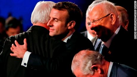 German President Frank-Walter Steinmeier (left) and his French counterpart Emmanuel Macron (center) hug.
