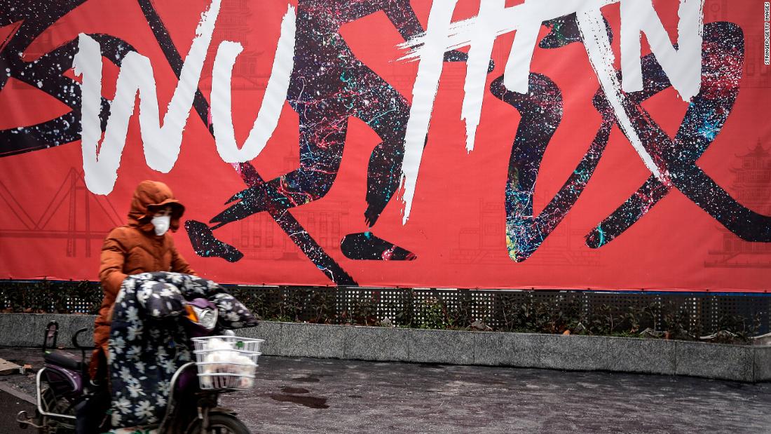 A woman rides an electric bicycle in Wuhan on Wednesday, January 22.