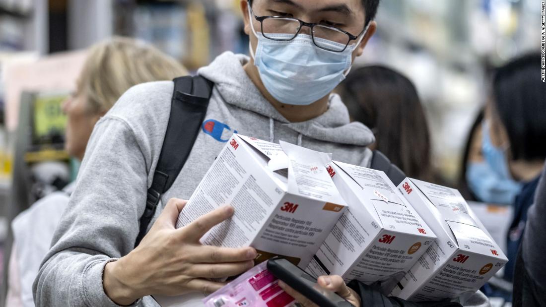 A customer holds boxes of particulate respirators at a pharmacy in Hong Kong on January 23, 2020.