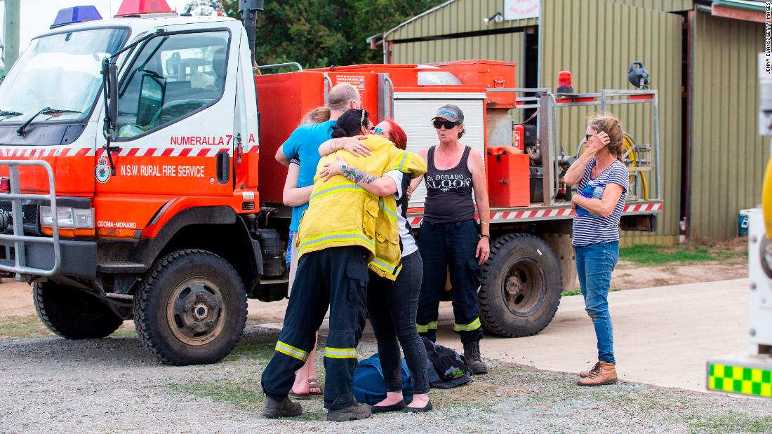 People embrace near the scene of a &lt;a href=&quot;https://www.cnn.com/2020/01/23/australia/australia-firefighter-crash-intl-hnk/index.html&quot; target=&quot;_blank&quot;&gt;water tanker plane crash&lt;/a&gt; in Cooma, Australia, on Thursday, January 23. Three American crew members died in the crash.
