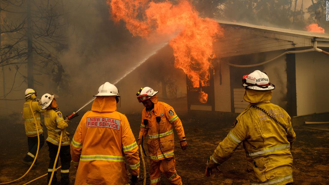Firefighters battle the Morton Fire as it burns a home near Bundanoon, Australia, on January 23.