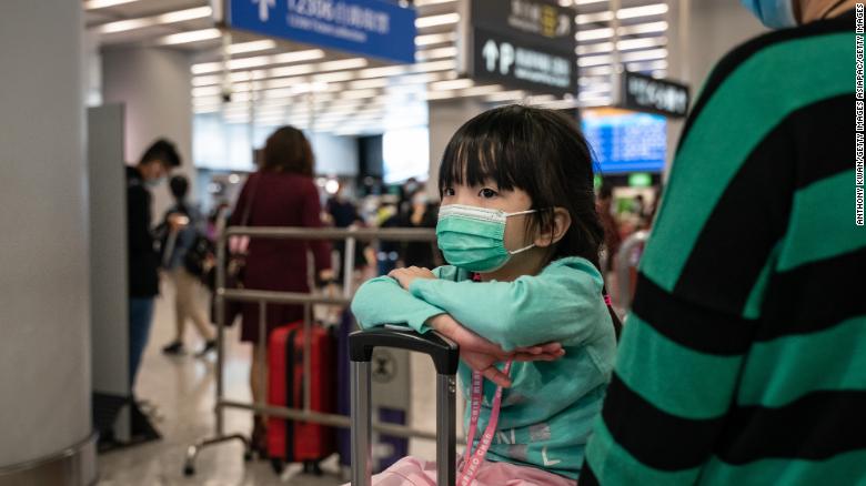 Travelers wearing face masks wait at the departure hall at West Kowloon Station on January 23, 2020 in Hong Kong.