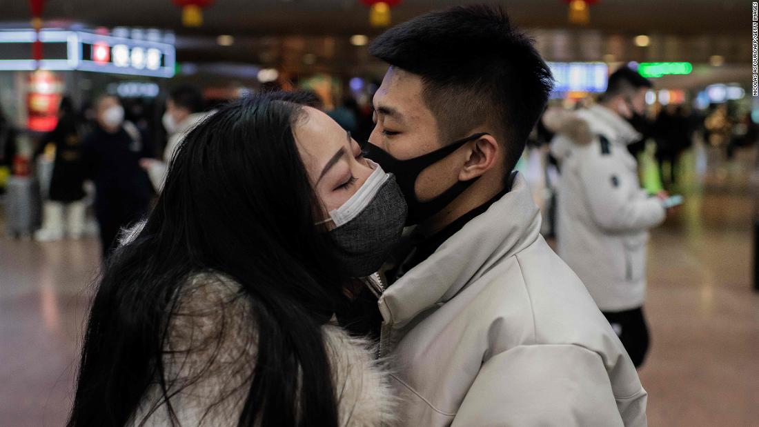 A couple kisses goodbye as they travel for the Lunar New Year holiday in Beijing on January 24, 2020.