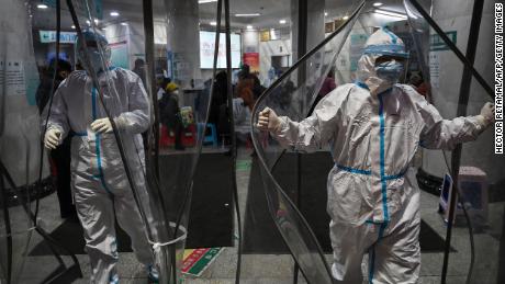 TOPSHOT - Medical staff members wearing protective clothing to help stop the spread of a deadly virus which began in the city, walk at the Wuhan Red Cross Hospital in Wuhan on January 25, 2020. - The Chinese army deployed medical specialists on January 25 to the epicentre of a spiralling viral outbreak that has killed 41 people and spread around the world, as millions spent their normally festive Lunar New Year holiday under lockdown. (Photo by Hector RETAMAL / AFP) (Photo by HECTOR RETAMAL/AFP via Getty Images)