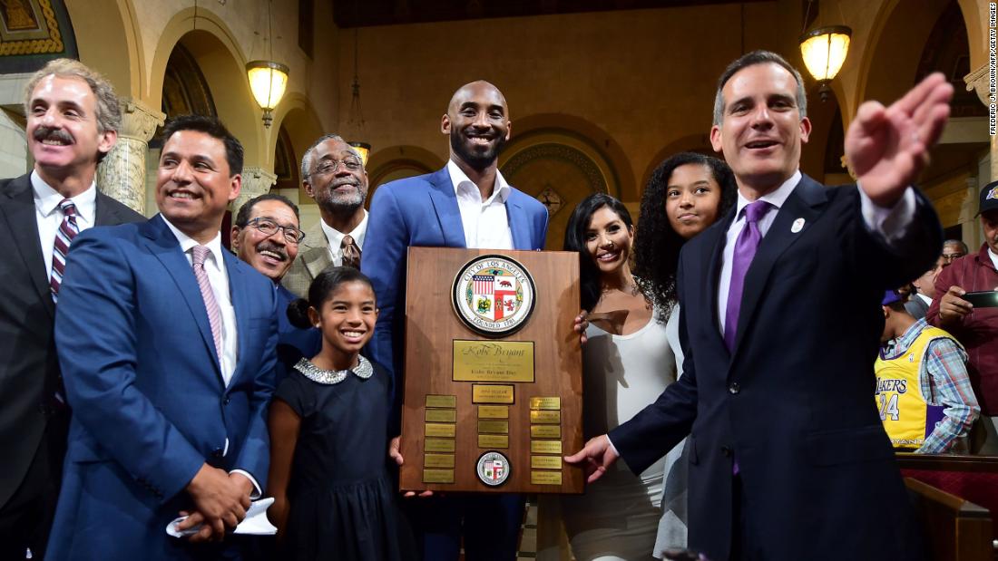 Los Angeles Mayor Eric Garcetti, right, gestures while posing with Bryant alongside members of his family and city officials in 2016. The city council announced August 24 as Kobe Bryant Day. The date commemorates the numbers Bryant wore as a Laker: 8 and 24.