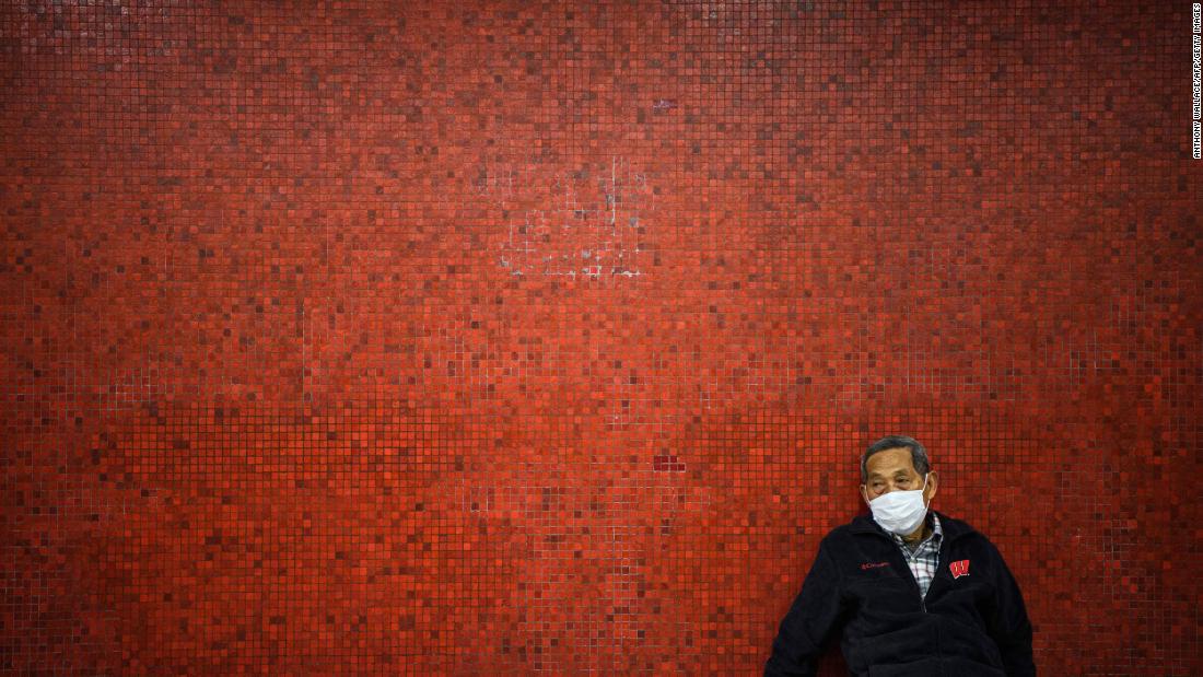 A man wearing a face mask sits on a bench as he waits on a platform for a MTR underground metro train in Hong Kong on January 27.