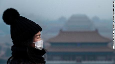 BEIJING, CHINA - JANUARY 26: A Chinese girl wears a protective mask as she stands on an overlook towards the Forbidden City, which was closed by authorities, during the Chinese New Year holiday  on January 26, 2020 in Beijing, China. The number of cases of a deadly new coronavirus rose to over 2000 in mainland China Sunday as health officials locked down the city of Wuhan earlier in the week in an effort to contain the spread of the pneumonia-like disease. Medical experts have confirmed the virus can be passed from human to human. In an unprecedented move, Chinese authorities put travel restrictions on the city which is the epicenter of the virus, and neighboring municipalities affecting tens of millions of people. The number of those who have died from the virus in China climbed to at least 56 on Sunday, and cases have been reported in other countries including the United States, Canada, Australia, France, Thailand, Japan, Taiwan and South Korea. (Photo by Kevin Frayer/Getty Images)