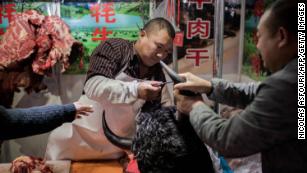 This picture taken on January 15, 2020 shows a butcher selling yak meat at a market in Beijing. 