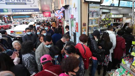 People queue for free face masks outside a cosmetics shop at Tsuen Wan in Hong Kong.