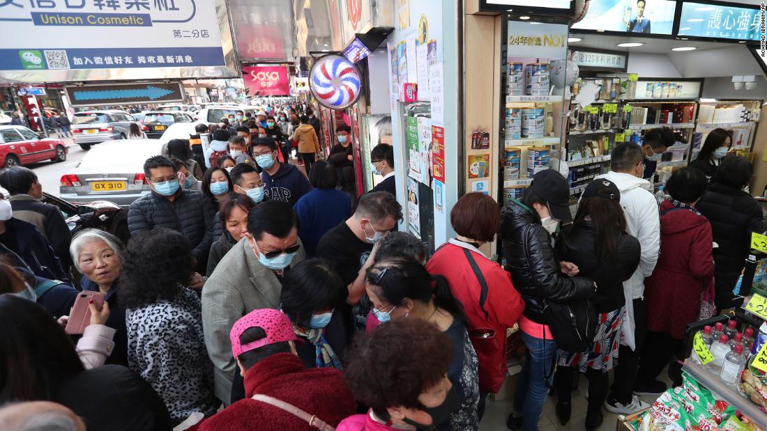 People queue for free face masks outside a cosmetics shop at Tsuen Wan in Hong Kong on January 28, 2020.