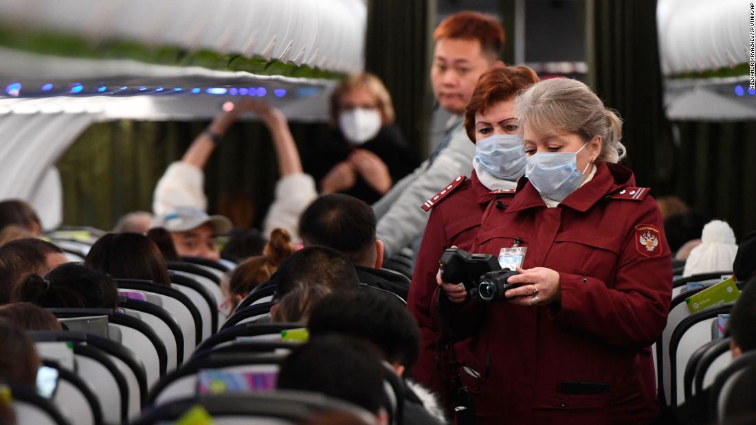 Workers at an airport in Novosibirsk, Russia, check the temperatures of passengers who arrived from Beijing on January 28, 2020.