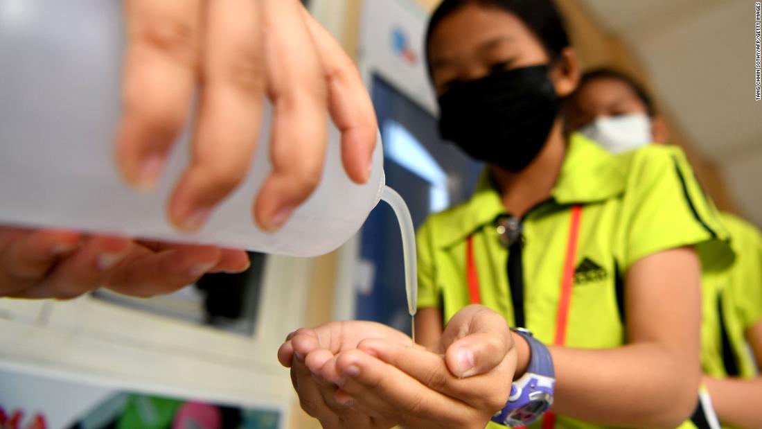 Students disinfect their hands with an alcohol solution before entering class in Phnom Penh, Cambodia, on January 28.