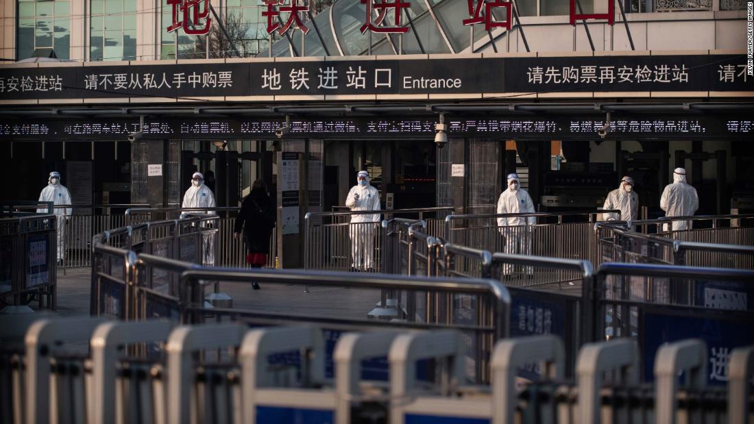 Chinese health workers standby to check the temperature of travelers entering a subway station in Beijing, China, on January 25.