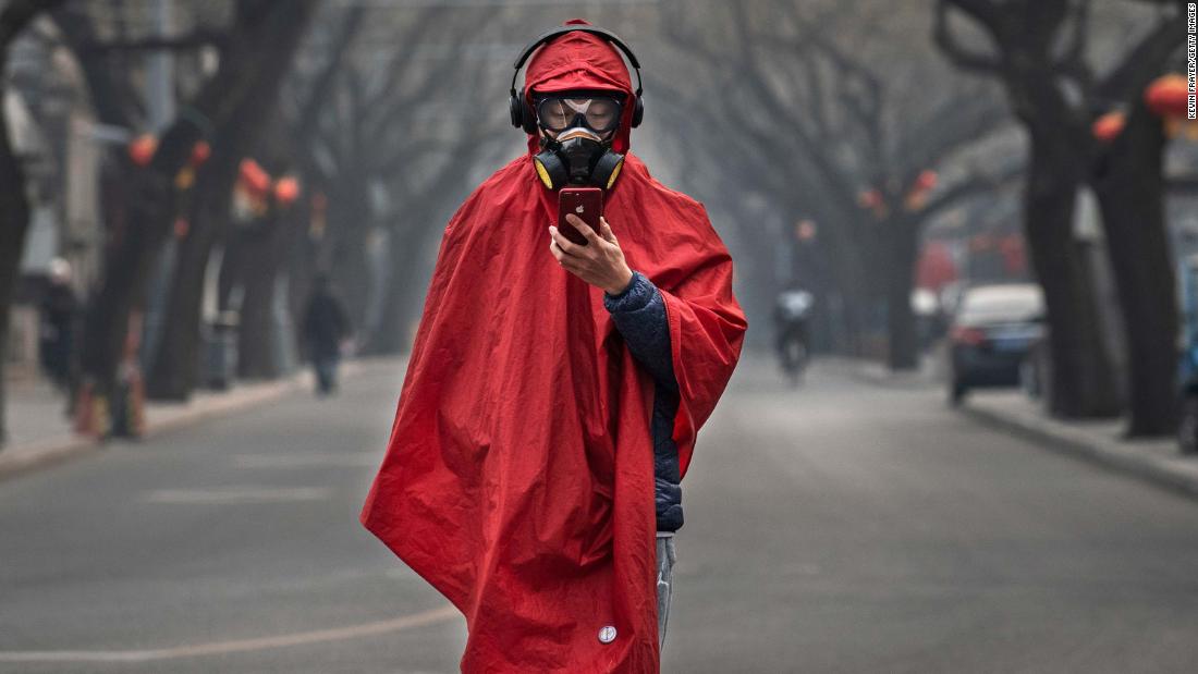 A man wears protective gear as he stands in a nearly empty street during the Chinese New Year holiday on January 26 in Beijing.