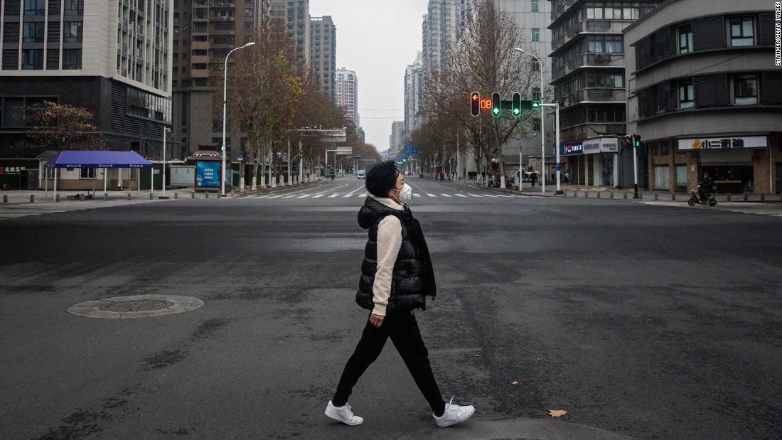 A woman crosses an empty road on January 27 in Wuhan.