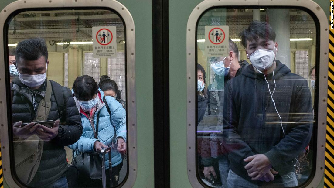 Passengers in Hong Kong wear protective masks as they wait to board a train at Lo Wu Station, near the mainland border.