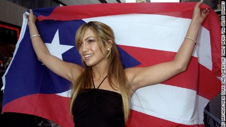 Jennifer Lopez carried a Puerto Rican flag as she arrived at a Virgin Megastore in New York to autograph her CD &quot;On the 6.&quot; in 1999. (Photo by Richard Corkery/NY Daily News Archive via Getty Images)