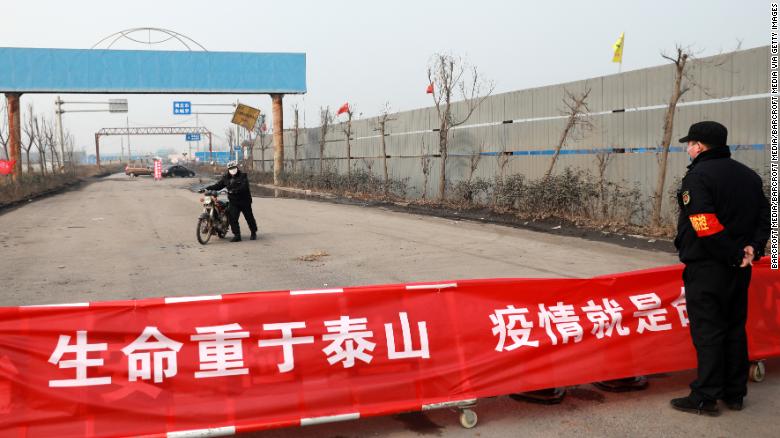 A motorbiker turns around at a road blockage and checkpoint in Huaibei in central China&#39;s Anhui province on January 29.