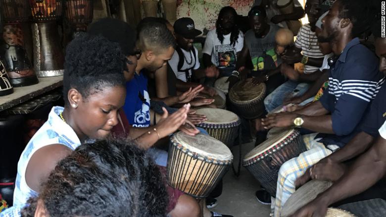 Scholars drumming with artisans from the Arts Centre Market in Accra, Ghana.