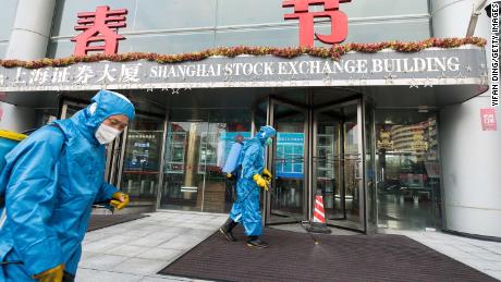 Medical workers spray antiseptic outside the Shanghai Stock Exchange on February 3, 2020.