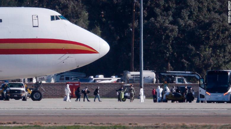 Hành khách lên xe buýt sau khi đến ngày 29 tháng 1 trên một chiếc máy bay chở công dân Hoa Kỳ đang được sơ tán khỏi Vũ Hán, Trung Quốc, tại Căn cứ Không quân Tháng ba ở Riverside, California. Tỉnh Hồ Bắc trong hai tuần trước khi họ trở về sẽ phải chịu tới 14 ngày cách ly bắt buộc.