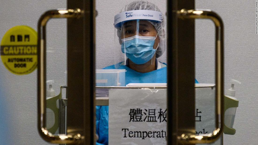 A medical worker wearing protective gear waits to take the temperature of people entering Princess Margaret Hospital in Hong Kong on February 4.