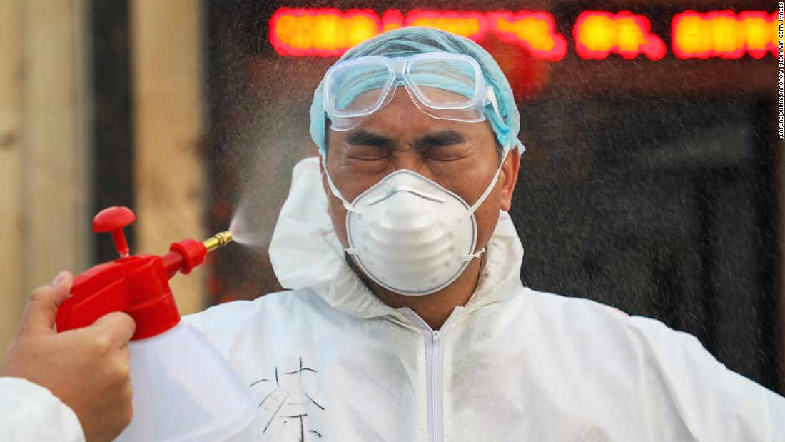 A colleague sprays disinfectant on a doctor in Wuhan on February 3.