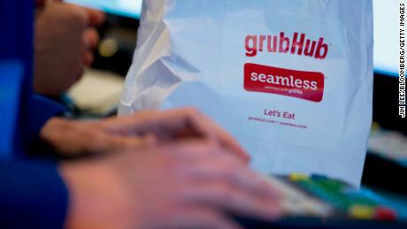 A trader works next to a Grubhub Inc. paper bag on the floor of the New York Stock Exchange (NYSE) in New York, U.S., on Friday, April 4, 2014. GrubHub Inc., which lets hungry city dwellers order food online, raised a higher-than-expected $192 million in an initial public offering, after pricing the shares above a marketed range. Photographer: Jin Lee/Bloomberg via Getty Images