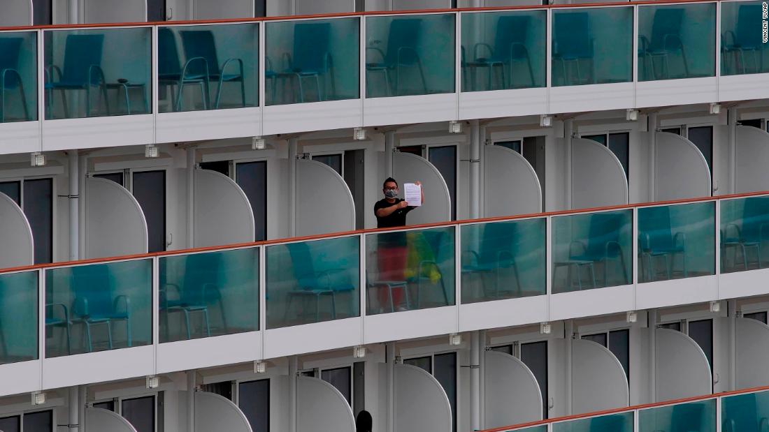 A passenger shows a note from the World Dream cruise ship docked at the Kai Tak cruise terminal in Hong Kong.
