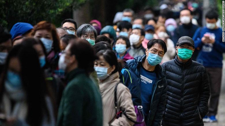 People wearing facemasks as a preventative measure following a coronavirus outbreak which began in the Chinese city of Wuhan, line up to purchase face masks from a makeshift stall after queueing for hours following a registration process during which they were given a pre-sales ticket, in Hong Kong on February 5, 2020. - The new coronavirus which appeared late December has claimed nearly 500 lives, infected more than 24,000 people in mainland China and spread to more than 20 countries. (Photo by Anthony WALLACE / AFP) (Photo by ANTHONY WALLACE/AFP via Getty Images)