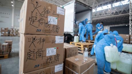 Staff members and volunteers transfer medical supplies at an exhibition center warehouse which has been converted into a makeshift hospital in Wuhan on February 4, 2020.