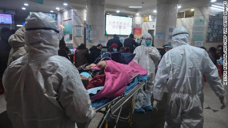 Medical staff arrive with a patient at the Wuhan Red Cross Hospital in Wuhan on January 25, 2020.