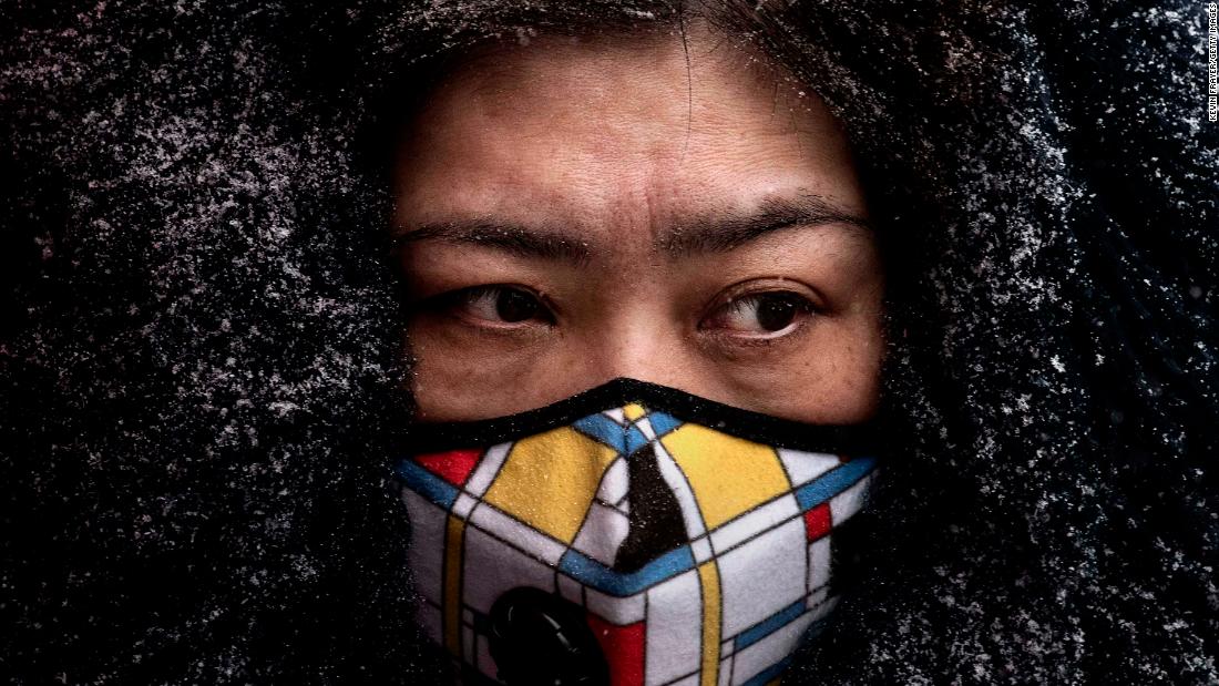 A woman wears a protective mask as she shops in a Beijing market on February 6, 2020.