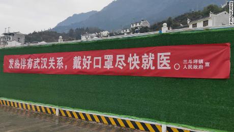 A banner in the Hubei town of Sandouping which reads, &quot;If (you) have fever and links to Wuhan, wear a mask and see a doctor.&quot;