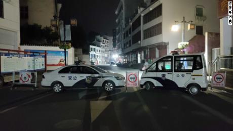 A road block set up by police vehicles on a street in Sandouping.