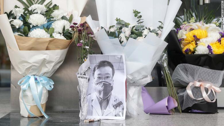 A photo of the late ophthalmologist Li Wenliang is seen with flower bouquets at the Houhu Branch of Wuhan Central Hospital in Wuhan on Friday.