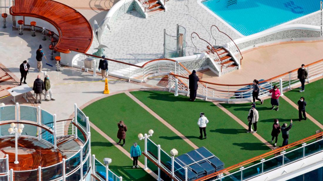 Passengers are seen on the deck of the Diamond Princess cruise ship, docked at the Yokohama Port on February 7.