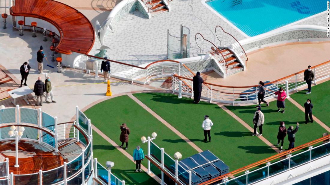 Passengers are seen on the deck of the Diamond Princess cruise ship, docked at the Yokohama Port on February 7, 2020.