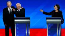 Democratic presidential candidate former Vice President Joe Biden, left, embraces Sen. Bernie Sanders, I-Vt., as Sen. Amy Klobuchar, D-Minn., right, watches during a Democratic presidential primary debate, Friday, Feb. 7, 2020, hosted by ABC News, Apple News, and WMUR-TV at Saint Anselm College in Manchester, N.H. (AP Photo/Elise Amendola)