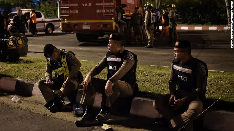 Police rest outside the Terminal 21 shopping mall after the shooting.