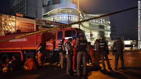 Police and firefighters stand outside the Terminal 21 shopping mall, where a mass shooting took place, in the Thai northeastern city of Nakhon Ratchasima on February 9.