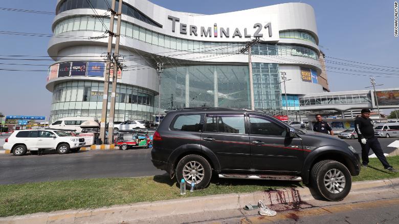 Thai rescue teams walk pass a shooting victim&#39;s vehicle outside Terminal 21 Korat mall.