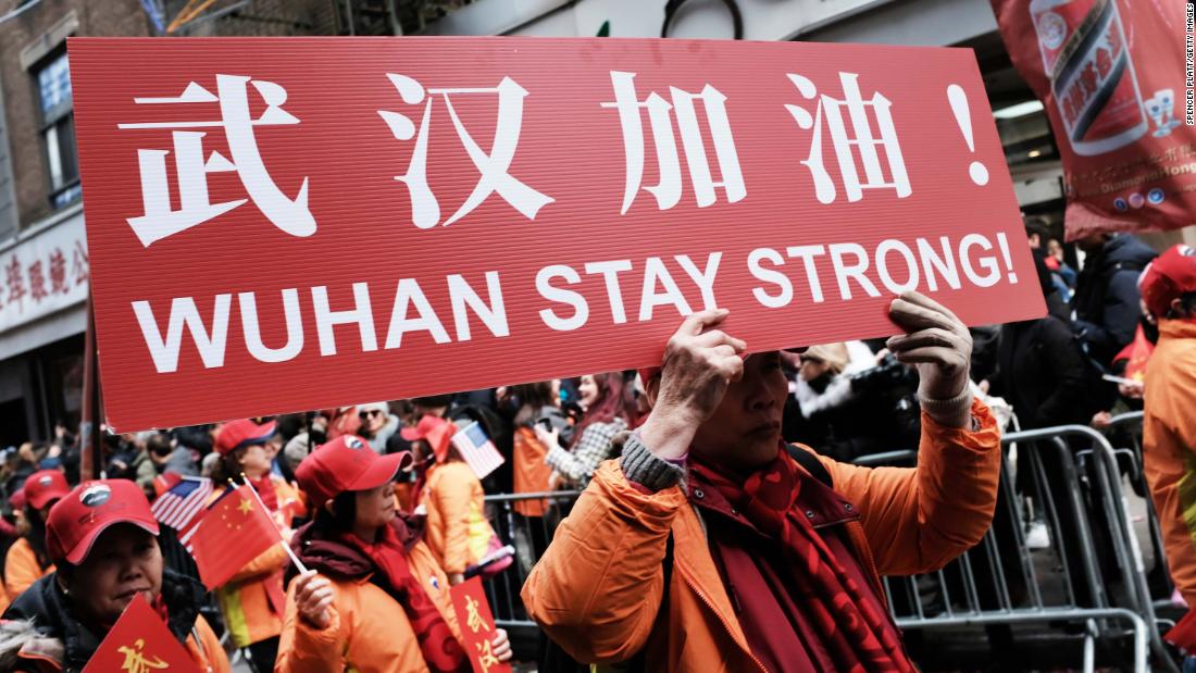 People participating in a Lunar New Year Parade in New York City hold signs reading, &quot;Wuhan stay strong!&quot; on February 9, 2020.