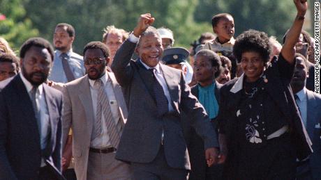 Nelson Mandela y su esposa Winnie saludan a una multitud que lo vitorea cuando sale de prisión el 11 de febrero de 1990.